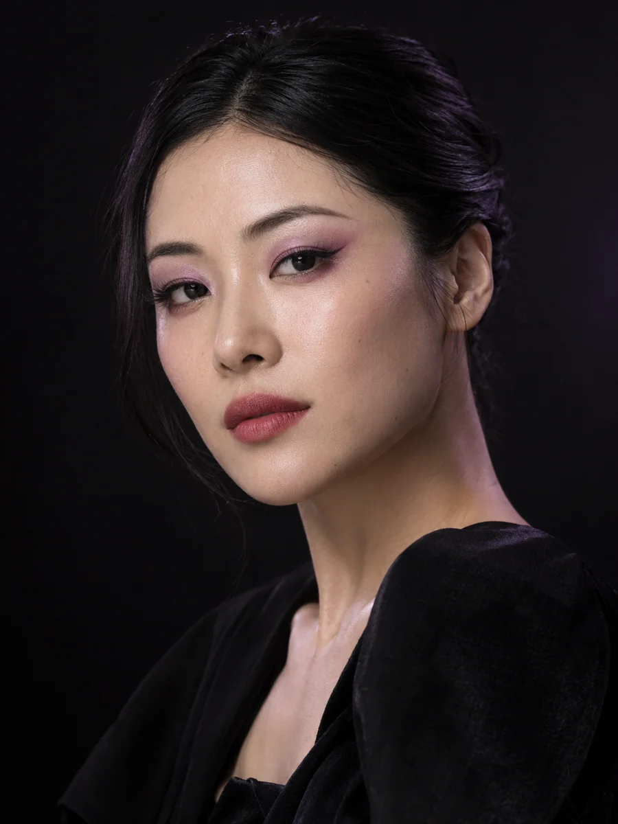 Editorial portrait with lavender eye makeup and expressive lip color